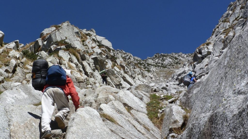 Trekkers climbing the rocky mountain trail
